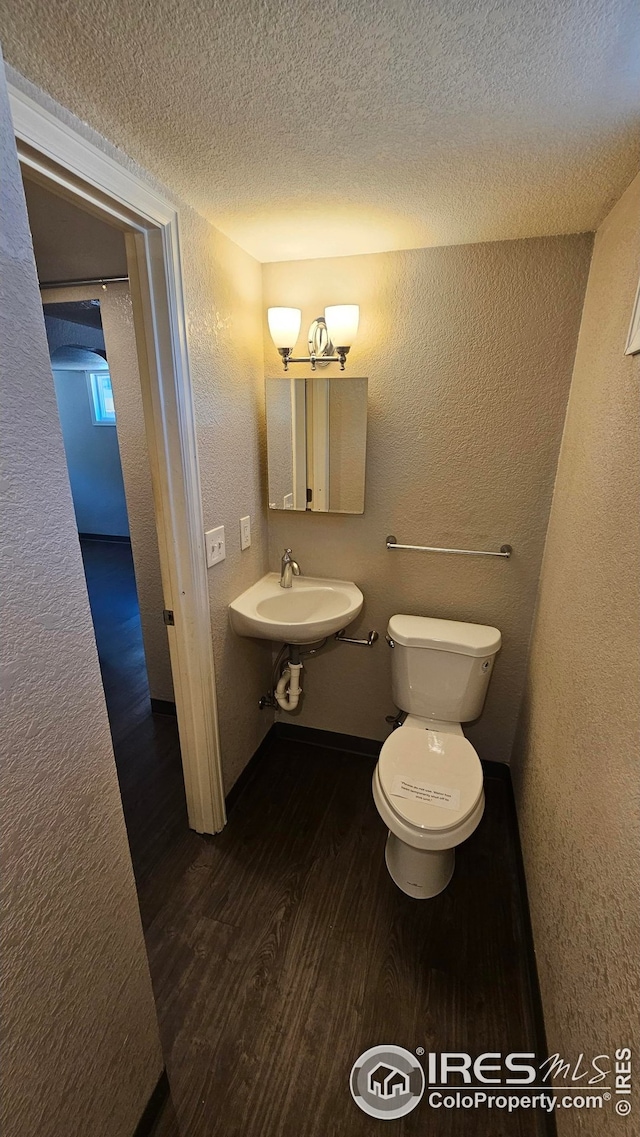 351 E 2nd St, Akron, CO 80720 - half bathroom with a textured wall, wood finished floors, and a textured ceiling