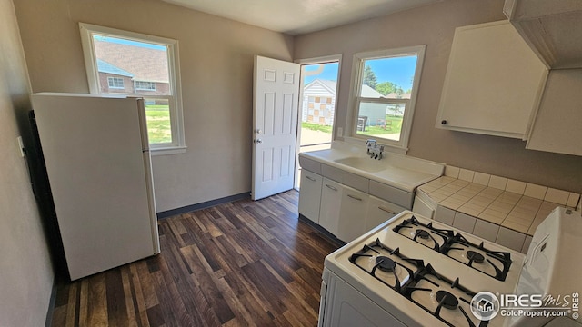 351 E 2nd St, Akron, CO 80720 - kitchen featuring white appliances, dark wood-type flooring, white cabinets, and tile counters