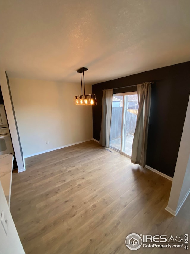 723 2nd St, Windsor, CO 80550 - unfurnished dining area with light wood-style flooring and a chandelier