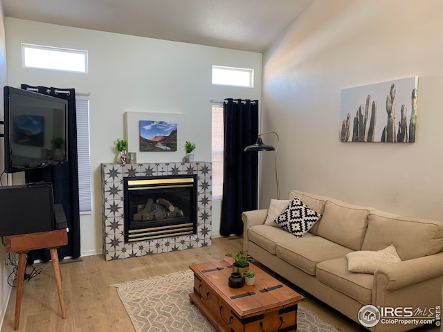 723 2nd St, Windsor, CO 80550 - living area featuring wood finished floors, healthy amount of natural light, and a tile fireplace