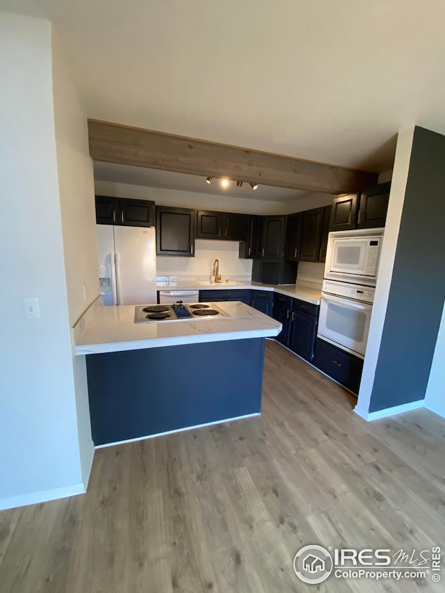 723 2nd St, Windsor, CO 80550 - kitchen featuring white appliances, a peninsula, light countertops, light wood-style flooring, and beam ceiling