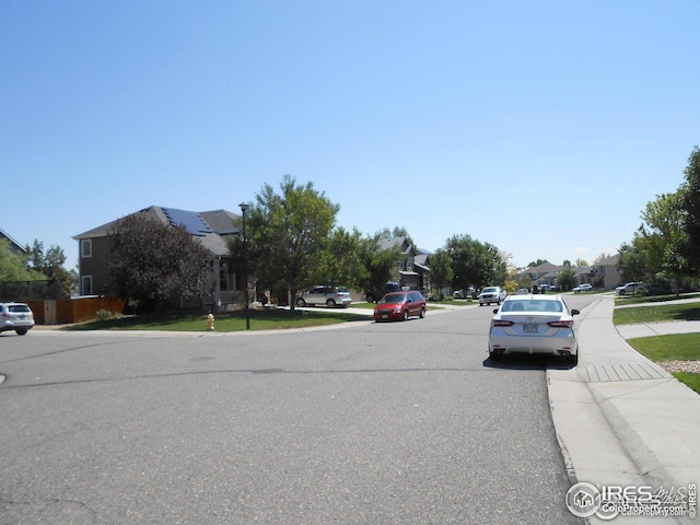 12609 Jersey Cir W, Thornton, CO 80602 - view of asphalt road with sidewalks, a residential view, and curbs
