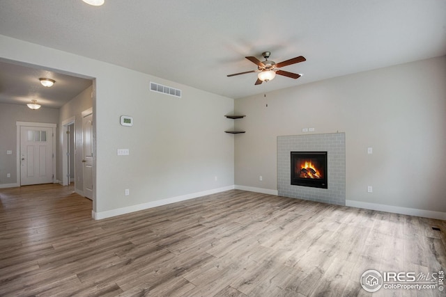 108 Wake St, Frederick, CO 80530 - unfurnished living room featuring ceiling fan, wood finished floors, and a tile fireplace