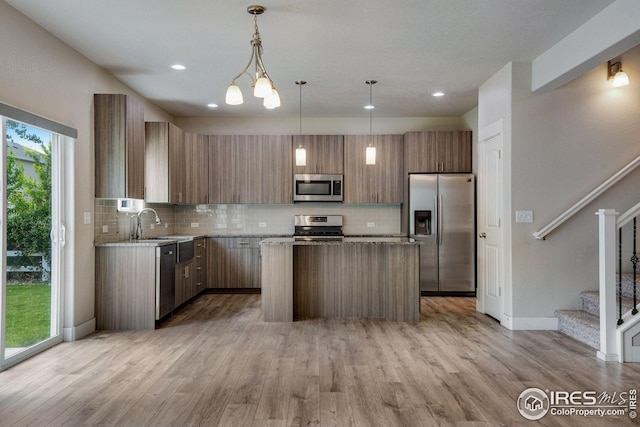 108 Wake St, Frederick, CO 80530 - kitchen featuring appliances with stainless steel finishes, a center island, tasteful backsplash, light wood-type flooring, and recessed lighting