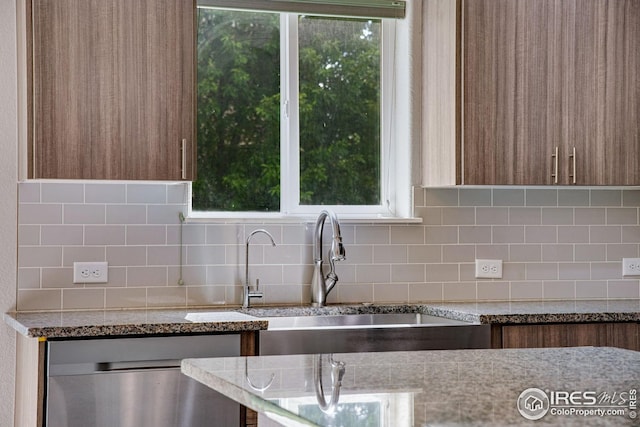 108 Wake St, Frederick, CO 80530 - kitchen featuring dishwasher, tasteful backsplash, light stone countertops, and brown cabinetry