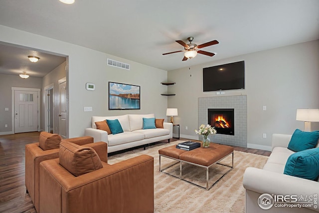 108 Wake St, Frederick, CO 80530 - living room featuring wood finished floors, a ceiling fan, and a tiled fireplace