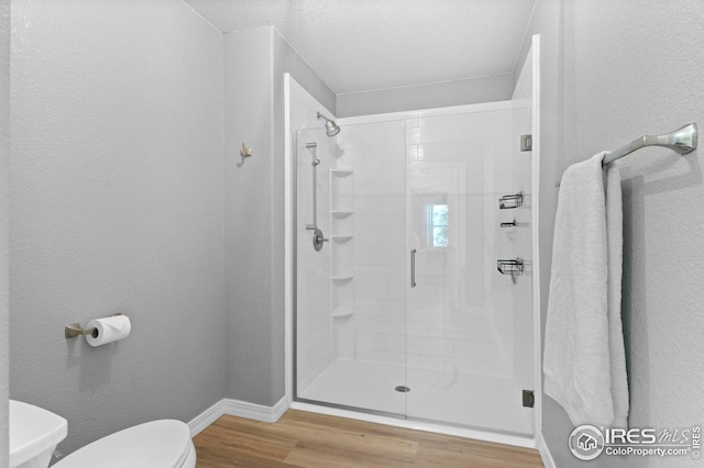 14300 Waterside Ln Unit E3, Broomfield, CO 80023 - full bathroom with a stall shower, wood finished floors, and a textured wall