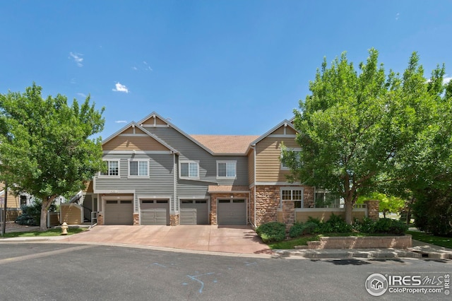 14300 Waterside Ln Unit E3, Broomfield, CO 80023 - view of front of house featuring an attached garage, driveway, and stone siding