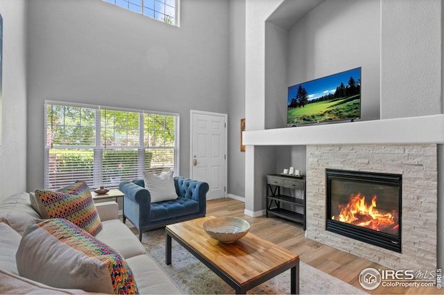 14300 Waterside Ln Unit E3, Broomfield, CO 80023 - living room featuring a towering ceiling, wood finished floors, and a fireplace