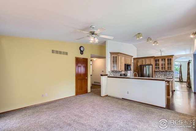 10947 W 100th Dr, Westminster, CO 80021 - kitchen with appliances with stainless steel finishes, arched walkways, vaulted ceiling, a ceiling fan, and a peninsula