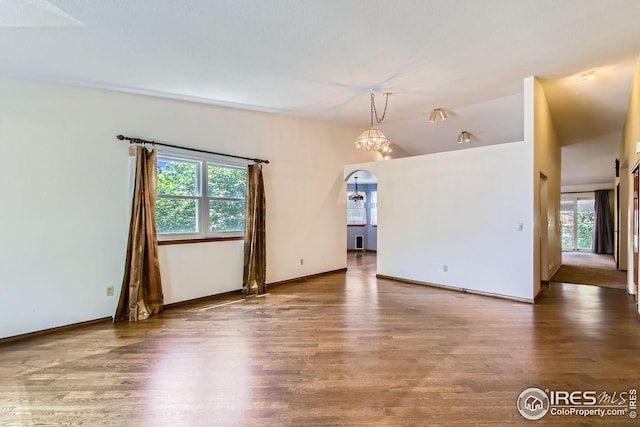 10947 W 100th Dr, Westminster, CO 80021 - spare room featuring healthy amount of natural light, wood finished floors, arched walkways, and vaulted ceiling