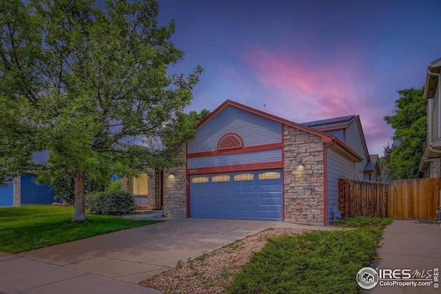 10947 W 100th Dr, Westminster, CO 80021 - view of front facade featuring stone siding, concrete driveway, and a garage