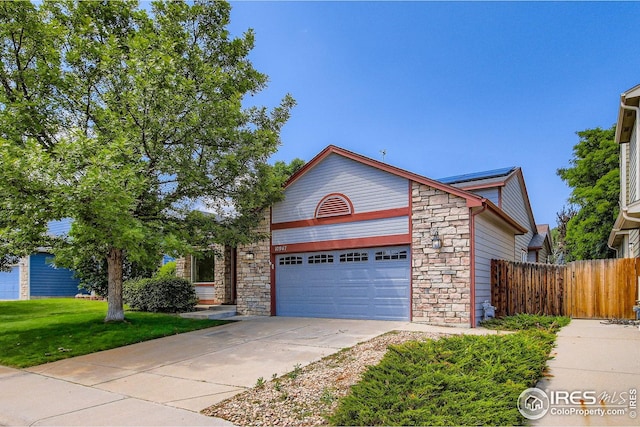 10947 W 100th Dr, Westminster, CO 80021 - view of front of house featuring stone siding, a garage, and concrete driveway