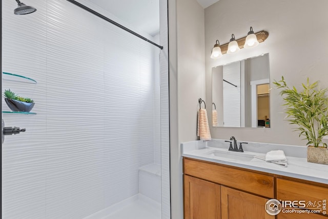 bathroom with vanity and tiled shower