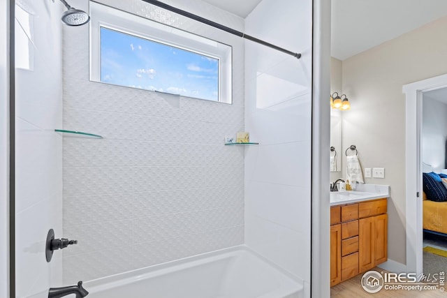 bathroom with tiled shower / bath combo and vanity