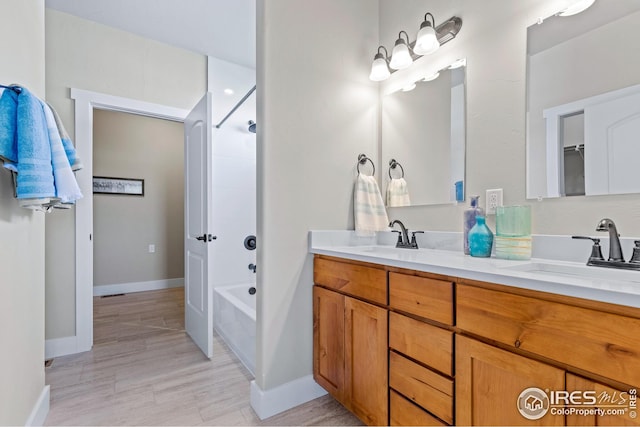 bathroom featuring dual bowl vanity and shower / washtub combination