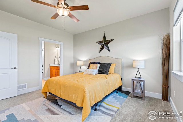 bedroom featuring ceiling fan, connected bathroom, and dark carpet