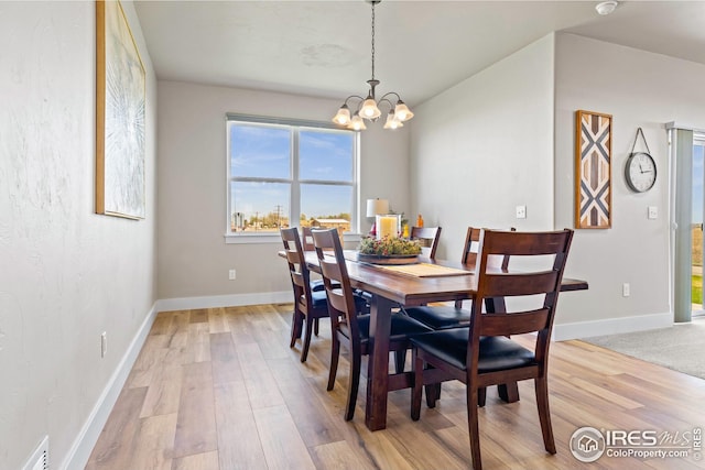 dining room featuring a notable chandelier, a wealth of natural light, and light hardwood / wood-style flooring