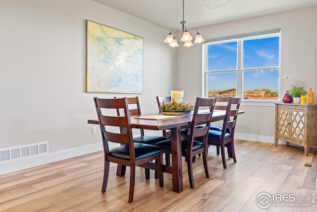 dining room featuring plenty of natural light, light wood-type flooring, and an inviting chandelier