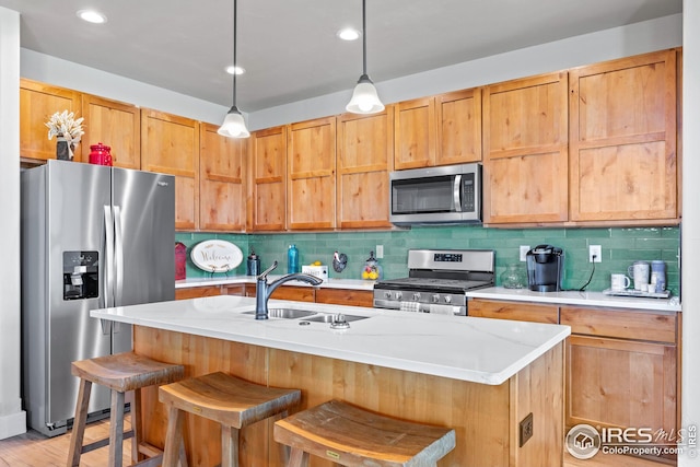 kitchen with hanging light fixtures, appliances with stainless steel finishes, light hardwood / wood-style floors, tasteful backsplash, and a breakfast bar area