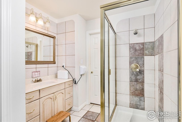 bathroom with tile walls, tile floors, vanity, and walk in shower