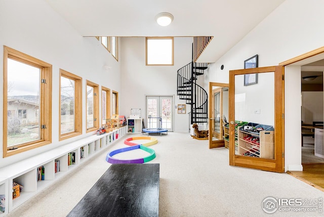 game room with high vaulted ceiling and light hardwood / wood-style flooring