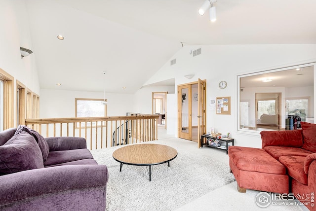 carpeted living room with a healthy amount of sunlight, ceiling fan, and lofted ceiling