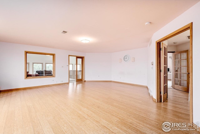 unfurnished room with light hardwood / wood-style floors and french doors