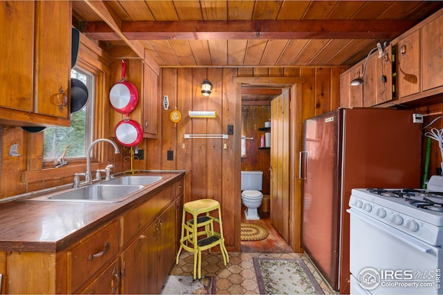 kitchen featuring wooden ceiling, beamed ceiling, and wooden walls