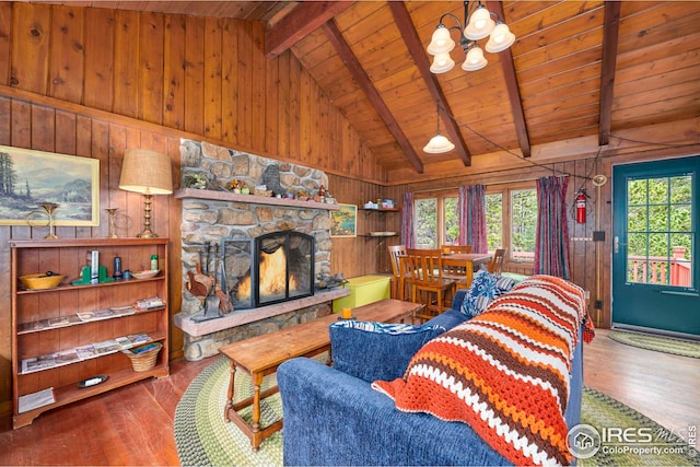 living room with vaulted ceiling with beams, a wealth of natural light, wood walls, and wooden ceiling