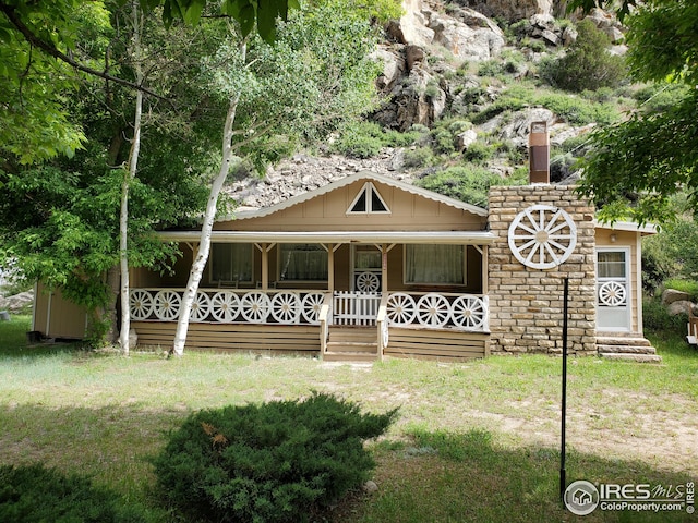 32246 Poudre Canyon Hwy, Bellvue, CO 80512 - view of front of house featuring a porch and a front yard