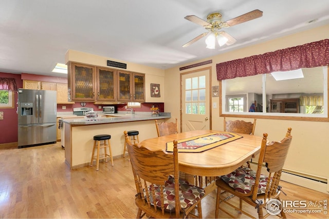 dining room with light hardwood / wood-style floors, sink, ceiling fan, and a baseboard radiator