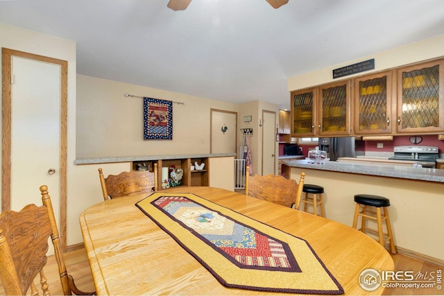 dining area with light hardwood / wood-style flooring and ceiling fan