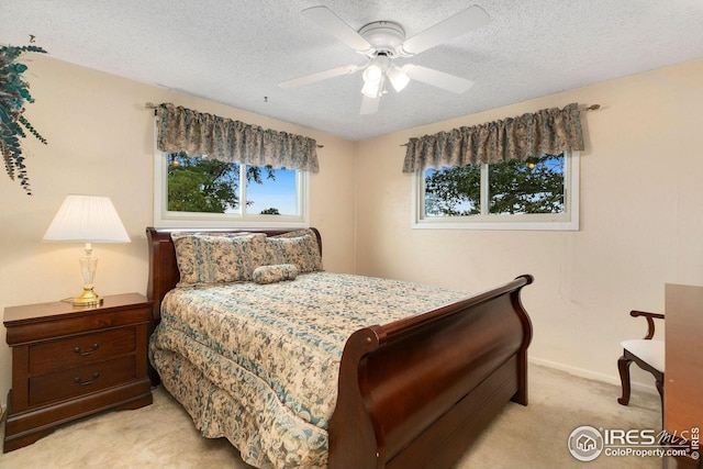 carpeted bedroom featuring ceiling fan and a textured ceiling