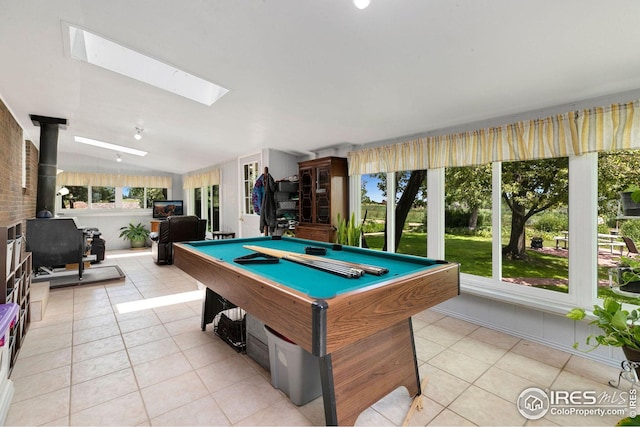 recreation room featuring a skylight, pool table, a wood stove, and a wealth of natural light