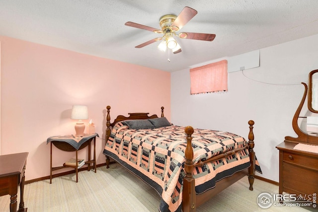 bedroom with ceiling fan, a textured ceiling, and light carpet