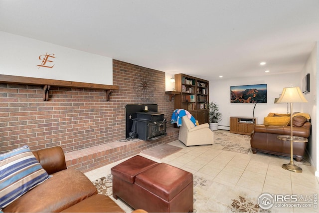 living room with a wood stove, baseboard heating, brick wall, and light tile patterned floors