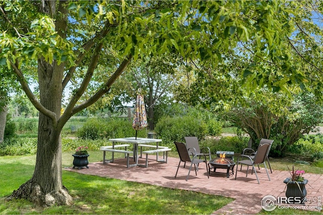 view of home's community with a patio, a yard, and an outdoor fire pit