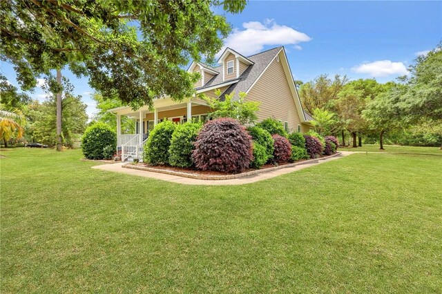view of property exterior featuring a porch and a yard