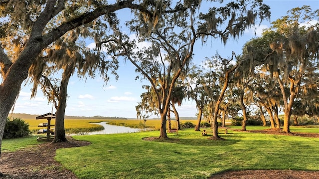 surrounding community with a yard and a water view