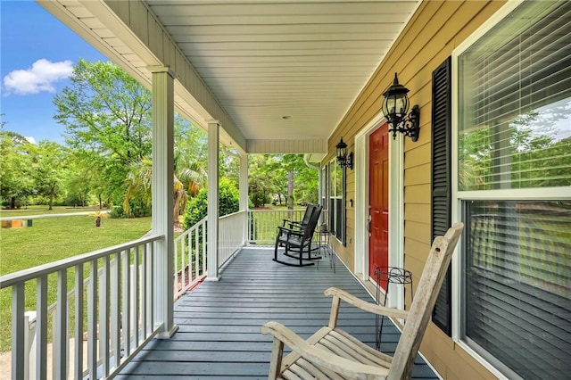 deck with a lawn and covered porch