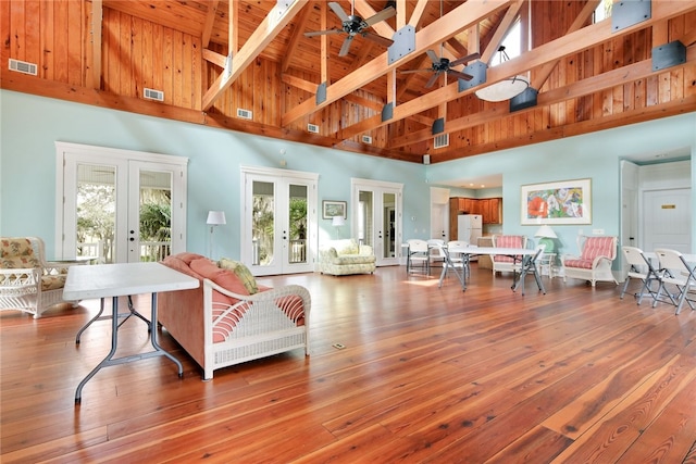 living area with high vaulted ceiling, a ceiling fan, french doors, and visible vents