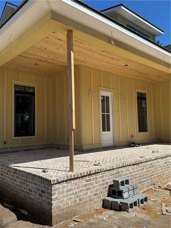 rear view of property with brick siding and board and batten siding