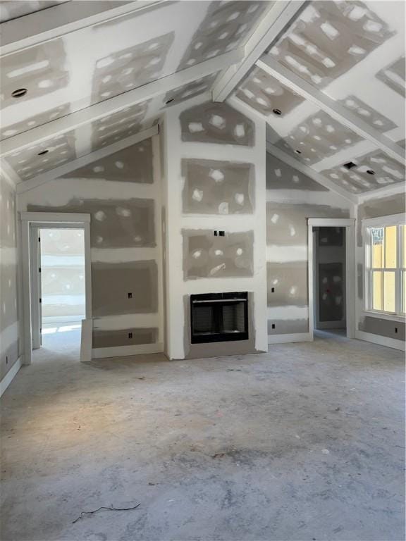 unfurnished living room featuring a glass covered fireplace and lofted ceiling