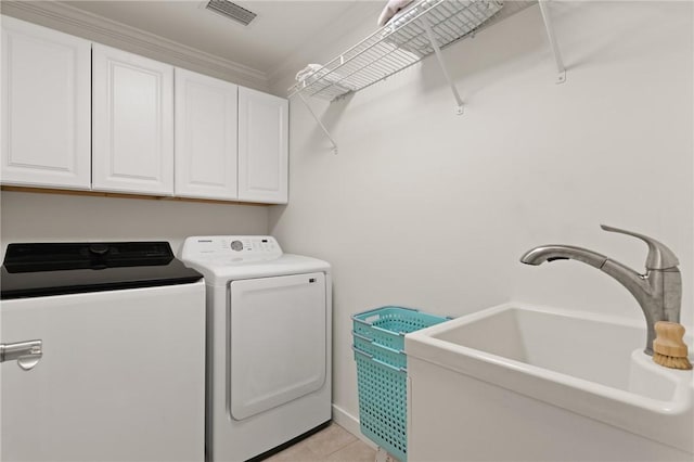 laundry room featuring washing machine and clothes dryer, light tile patterned floors, cabinet space, visible vents, and a sink