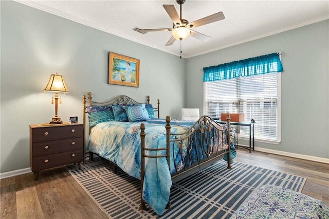 bedroom featuring ornamental molding, baseboards, and wood finished floors