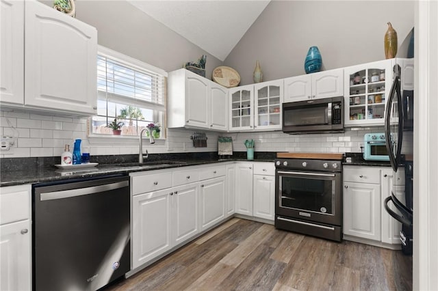 kitchen featuring lofted ceiling, a sink, electric stove, dishwasher, and stainless steel microwave