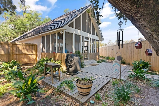 exterior space with a sunroom, fence, and a wooden deck