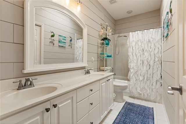 bathroom featuring toilet, shower / bathtub combination with curtain, double vanity, and a sink