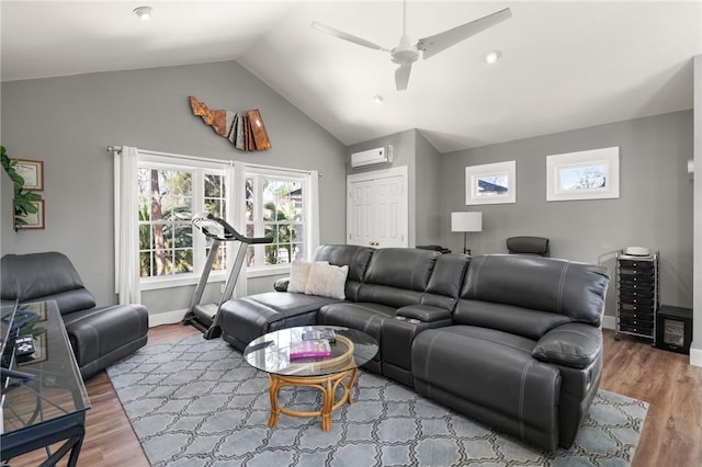 living area featuring lofted ceiling, wood finished floors, a ceiling fan, baseboards, and a wall mounted AC